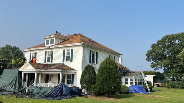 A large home with exposed roof decking during a replacement