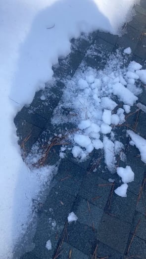 Snow accumulated on the slope of a residential roof