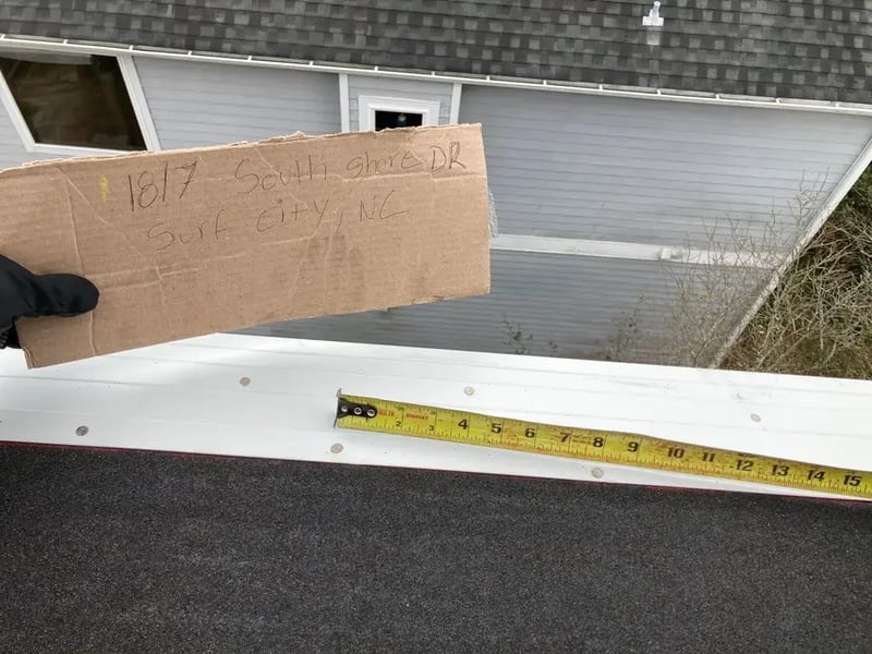 New metal drip edge being measured and set at the eave during a FORTIFIED roof installation in North Carolina