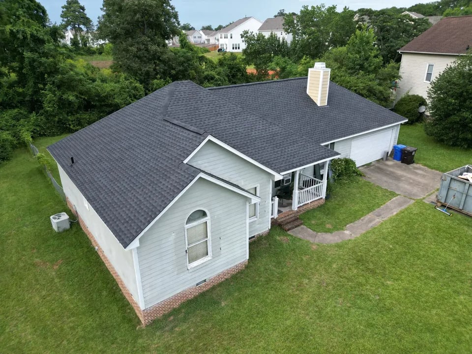 Close-up of new GAF Timberline HDZ Charcoal shingles on a finished roof repair section of an Angier, NC home