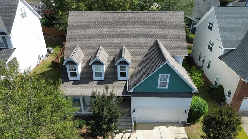 Aerial view of completed charcoal shingle roof replacement on a two-story home with dormers in Cary, NC