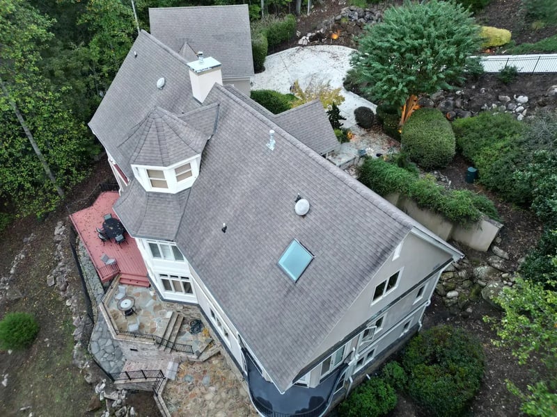 Aerial drone view of completed gray shingle roof replacement on a luxury home with octagonal turret in Chapel Hill's Governors Club