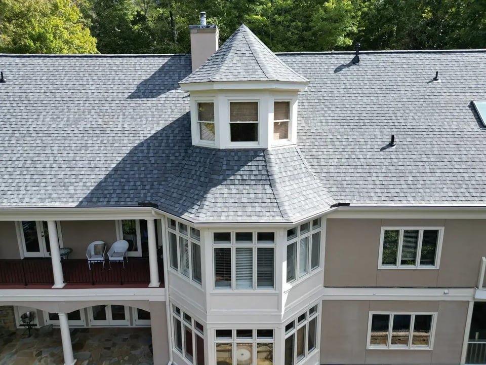 Completed roof replacement on a Chapel Hill home at Governors Club with new gray architectural shingles, white cupola, and clean ridges