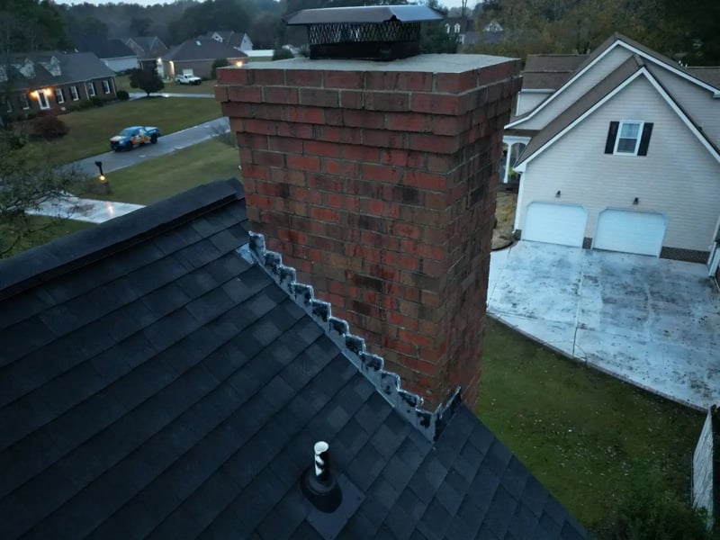Twilight aerial of completed dark navy shingle roof replacement on a white two-story colonial home in Goldsboro, NC