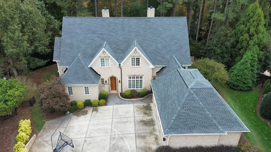Slate GAF UHDZ shingles on an estate-scale Raleigh home with stone entry accents and three brick chimneys