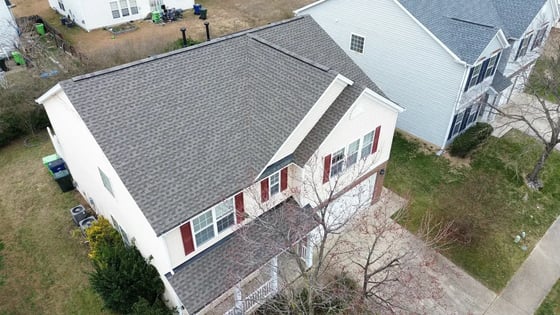 Weathered Wood GAF HDZ shingle roof on a cream two-story Raleigh home with red shutters on Roaring Rapids Rd