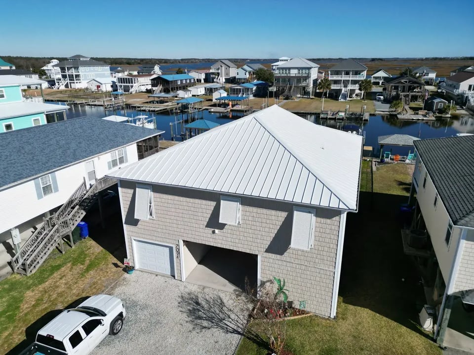 Aerial view of a completed roof inspection and standing-seam metal installation on 7th St in Surf City, NC