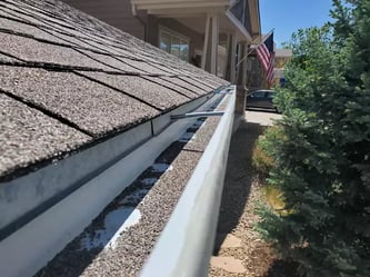 asphalt shingle granules in a gutter_WebP