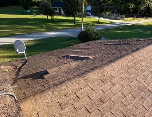 Curled and damaged asphalt shingles on a roof