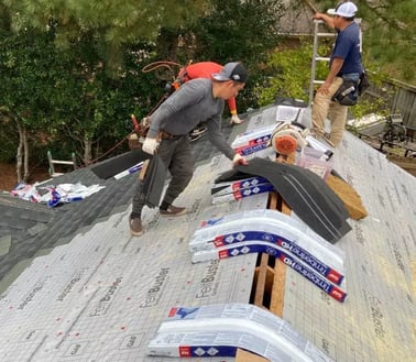 Roofing contractors working on a storm-damaged roof