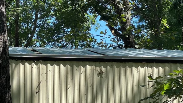 A metal roof being installed over existing shingles
