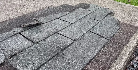 Old worn three-tab shingles on a roof