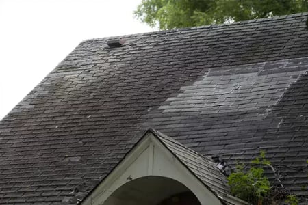 Patched and damaged shingles on a failing roof