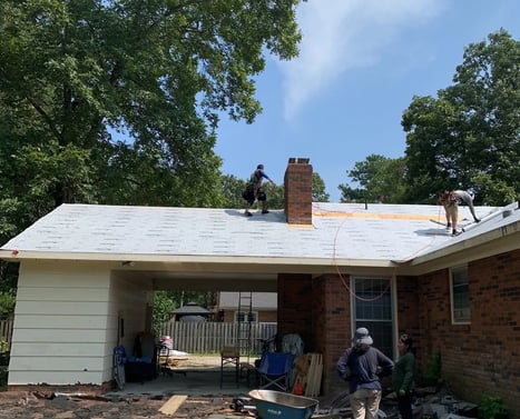 Roofing crew working on a residential roof replacement