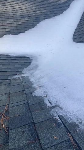 Snow collected in the valley of a shingle roof