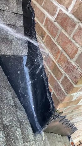 Roofer running water across a roof section during a water test