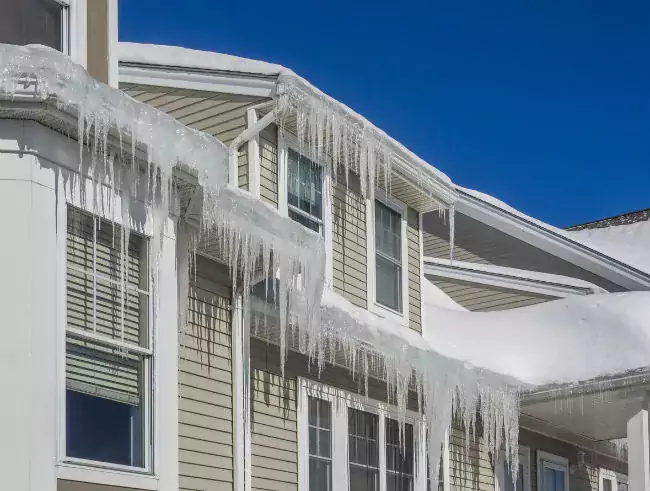 Icicles hanging on the edge of a roof as a result of ice damming