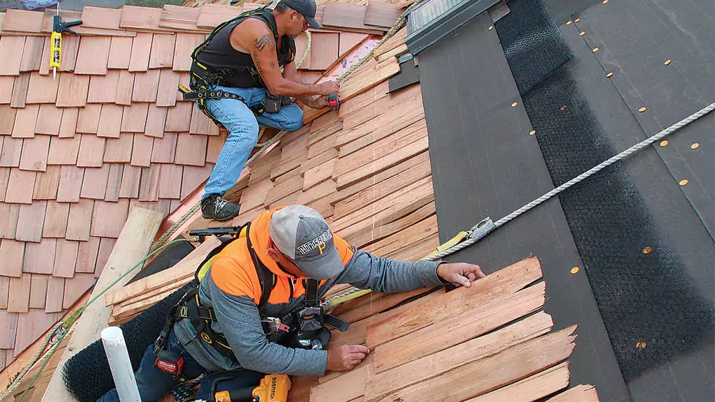 Roofers installing cedar shake shingles