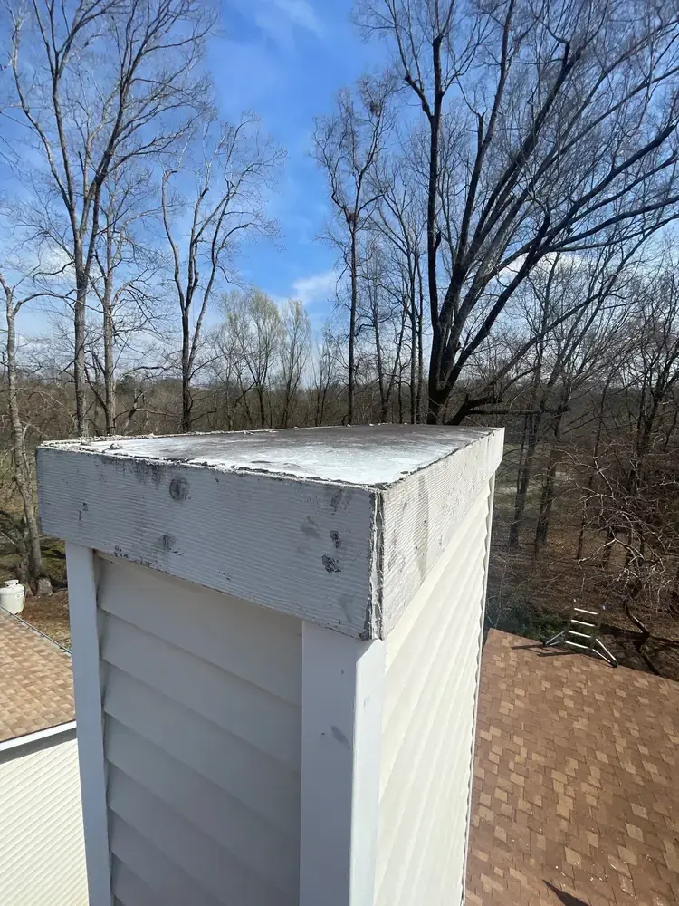 Chimney cap and roof penetration area showing condition before repair