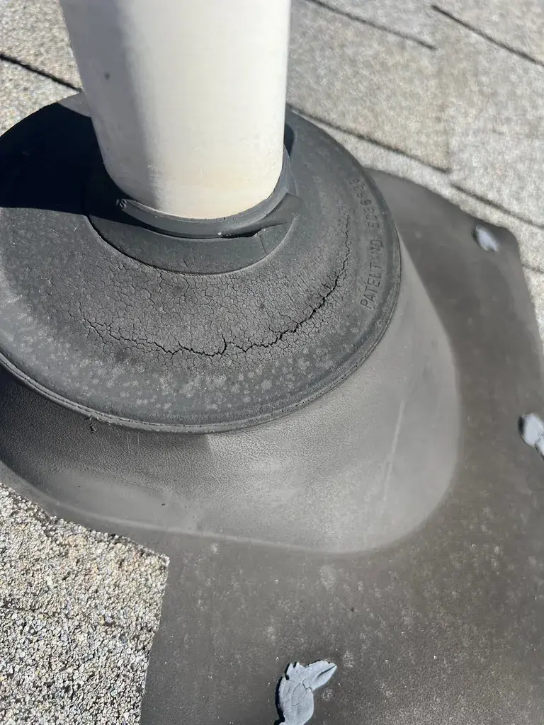 Cracked rubber pipe boot around plumbing vent showing deterioration and separation