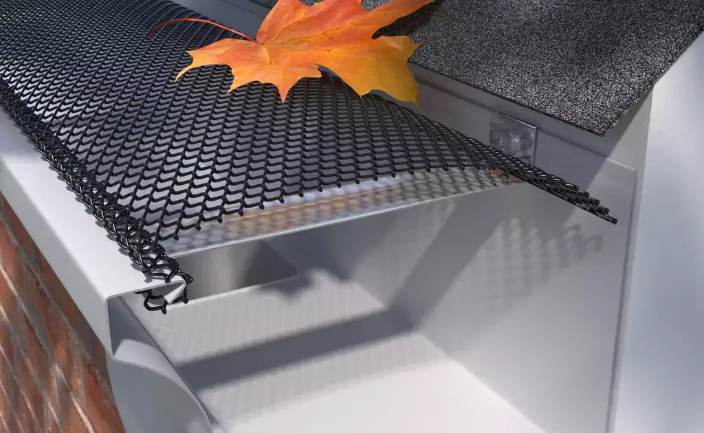 black mesh gutter screen preventing an orange leaf from falling into a gutter