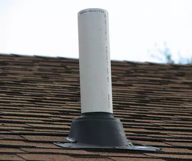 black plastic boot covering the base of a white roof pipe