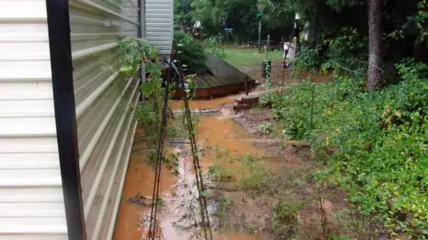 brown, muddy water pooling around the foundation of a home