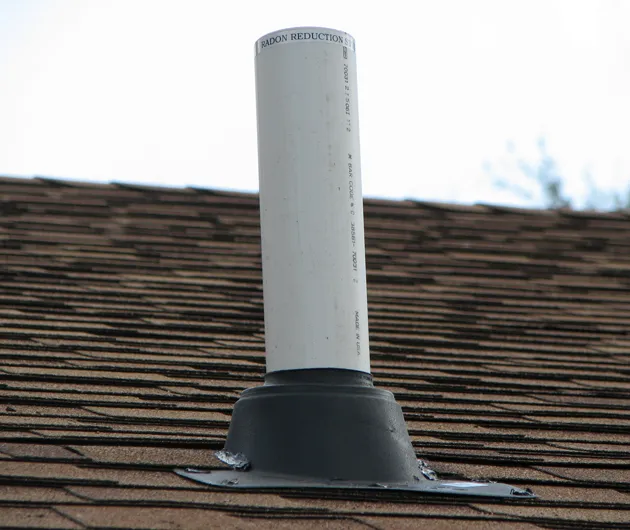 black plastic boot covering the base of a white roof pipe_WebP