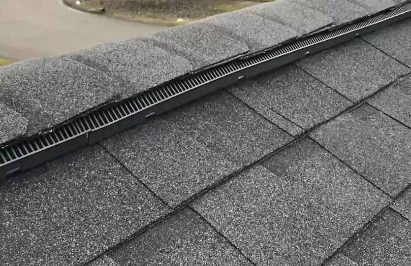 ridge vent on the top of a gray shingle roof