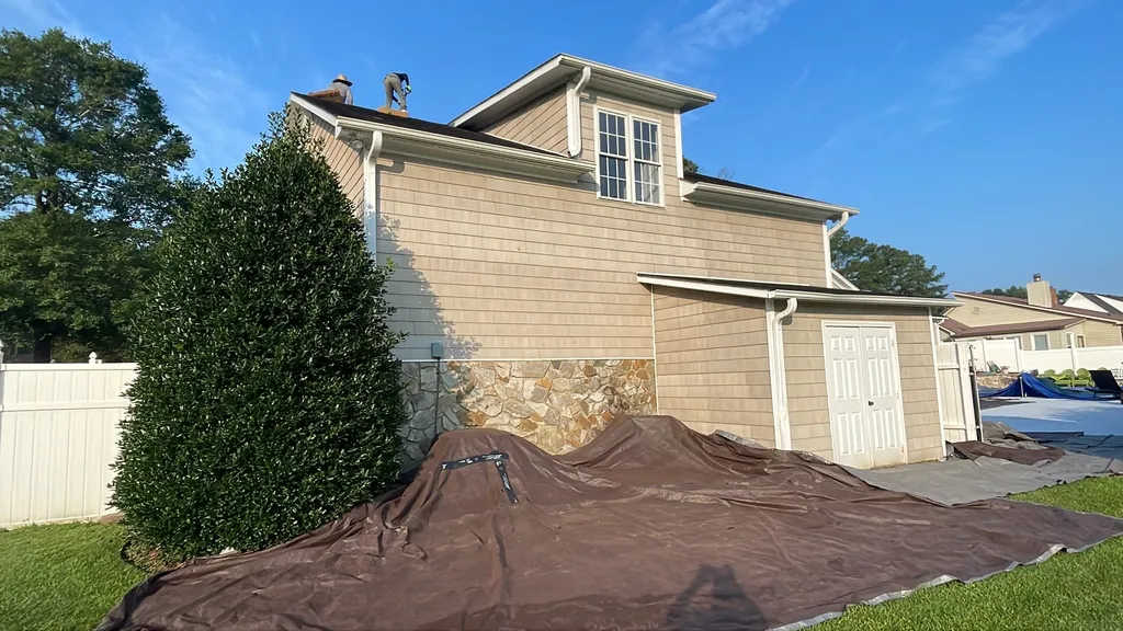 Tarps laid on the ground to protect landscaping during a roof replacement
